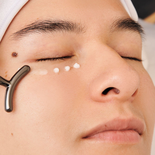 Using the Dermathod Massage Stick over an eye serum; an absorption solution that solves "product waste" by using a smooth, non-porous surface to drive active ingredients deeper into the skin without absorbing any serum itself.