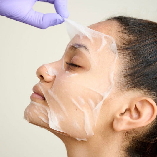 Close-up of the ultra-thin Tencel KrX Korean Glycolic Mask adhering to the face; a second-skin solution that solves "active-evaporation" by using semi-occlusive technology to drive glycolic acid deeper into the skin.