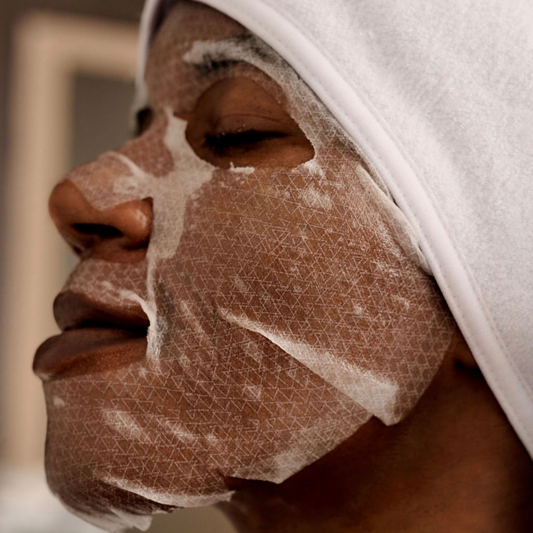 Applying the premium Korean Thesera Superbly Shape Holding Mask, showing the high-adhesion second-skin biocellulose material.