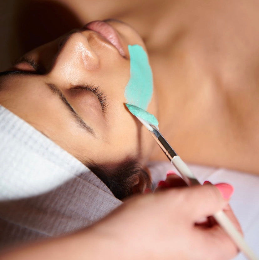Close-up of the non-shedding fan brush applying a treatment mask; high-density vegan bristles ensure a smooth, hair-free finish on the skin.