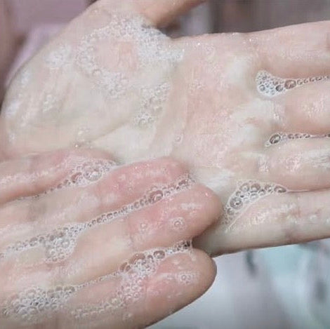 Close-up of the silky, pH-balanced lather created by Corthe Super Enzyme Powder, designed to gently digest dead skin cells while keeping the moisture barrier intact.