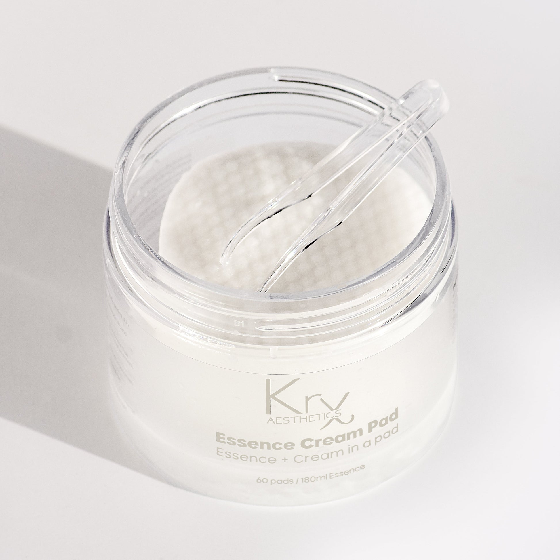 Close-up of KrX Korean Essence Cream Pads saturated in a rich, milky essence; designed to deliver the benefits of a toner, essence, and cream in one non-exfoliating step.