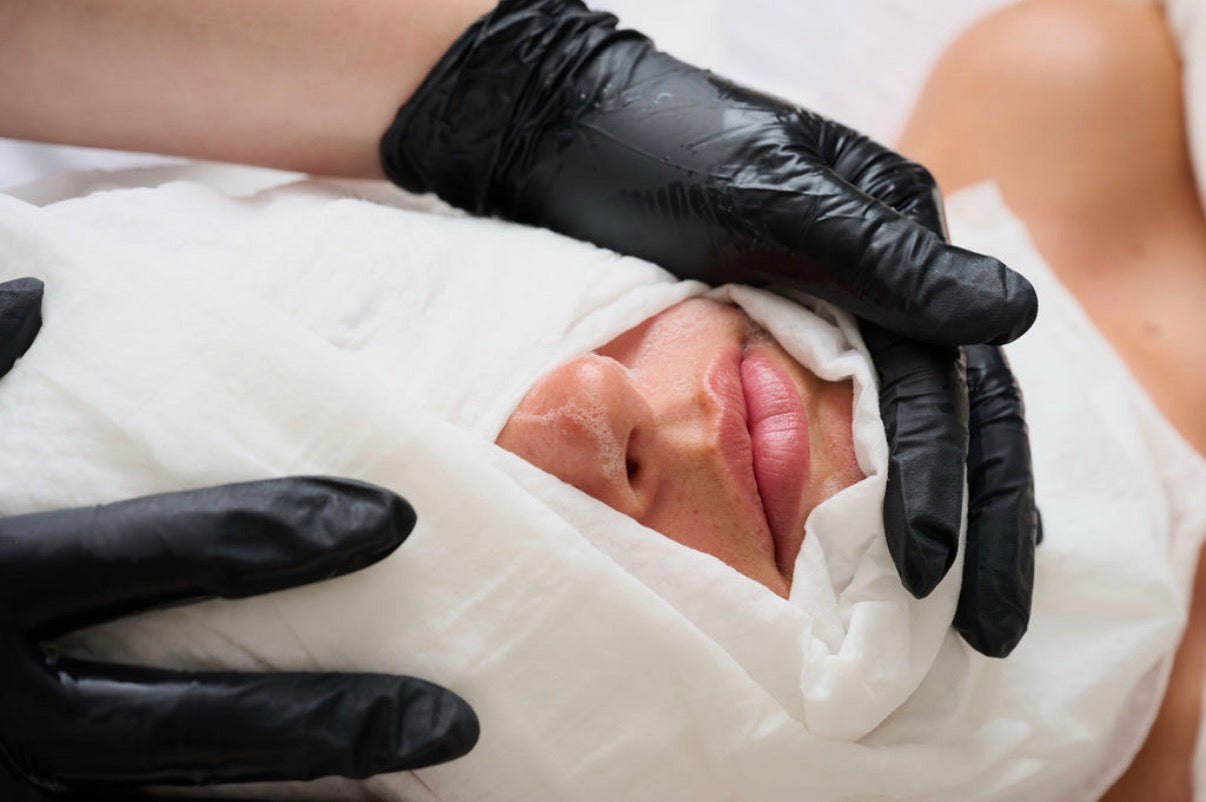Licensed aesthetician applying a professional-grade Korean facial treatment to a client for smooth, radiant glass skin.