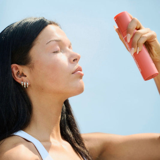 Misting face with KrX Korean Hypochlorous Acid Mist for lightweight, refreshing antimicrobial defense and post-workout skin calming.