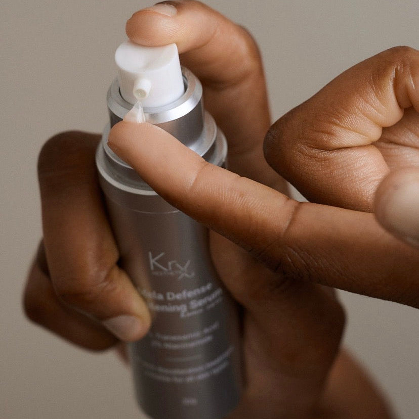 Dispensing the KrX Mela Défense Brightening Serum, a professional clinical treatment that targets dark spots and sun damage while supporting the skin barrier.