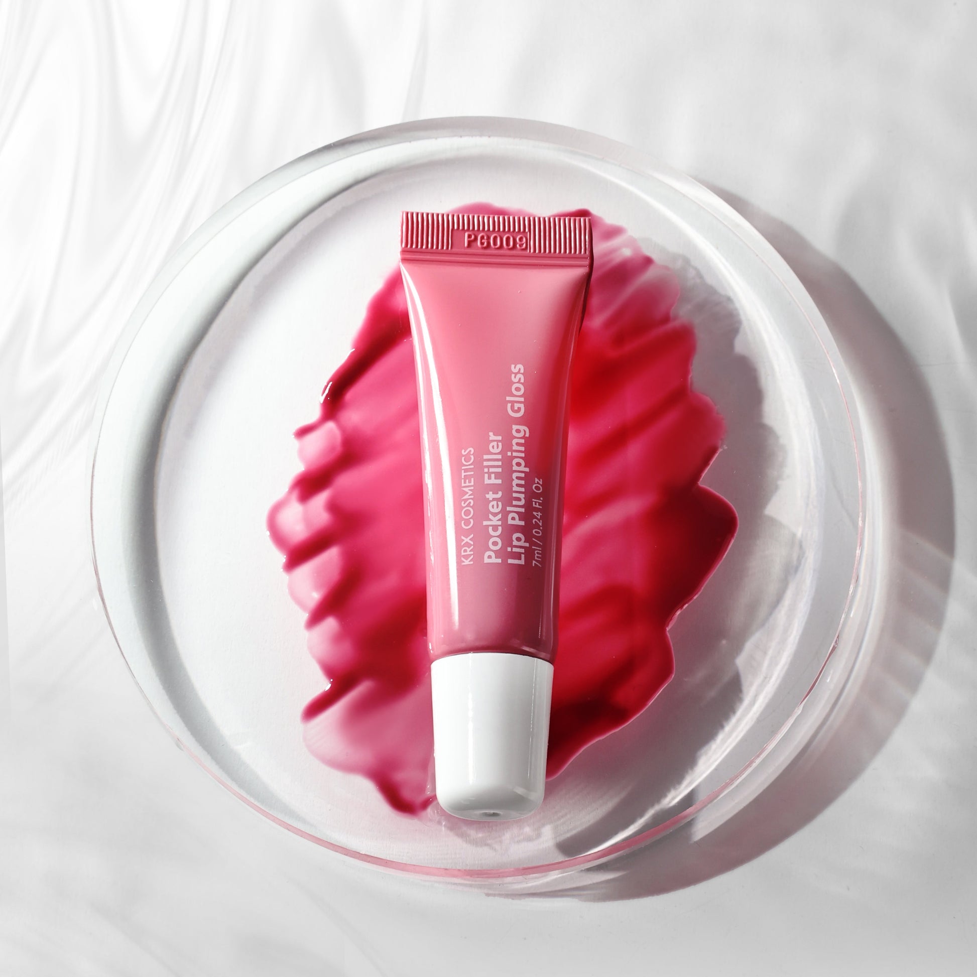 Close-up of the "Red" KrX Pocket Filler texture; a non-sticky, pigment-rich plumping gloss that delivers a dimensional, juicy pout with Vitamin E for barrier repair.