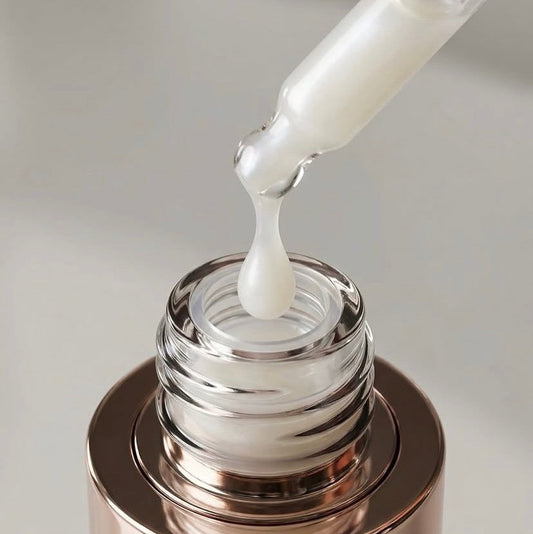 Close-up of a milky white, lightweight emulsion serum on a glass pipette dropper, showing a fast-absorbing, non-pilling 15% Niacinamide and Korean ceramide formula.