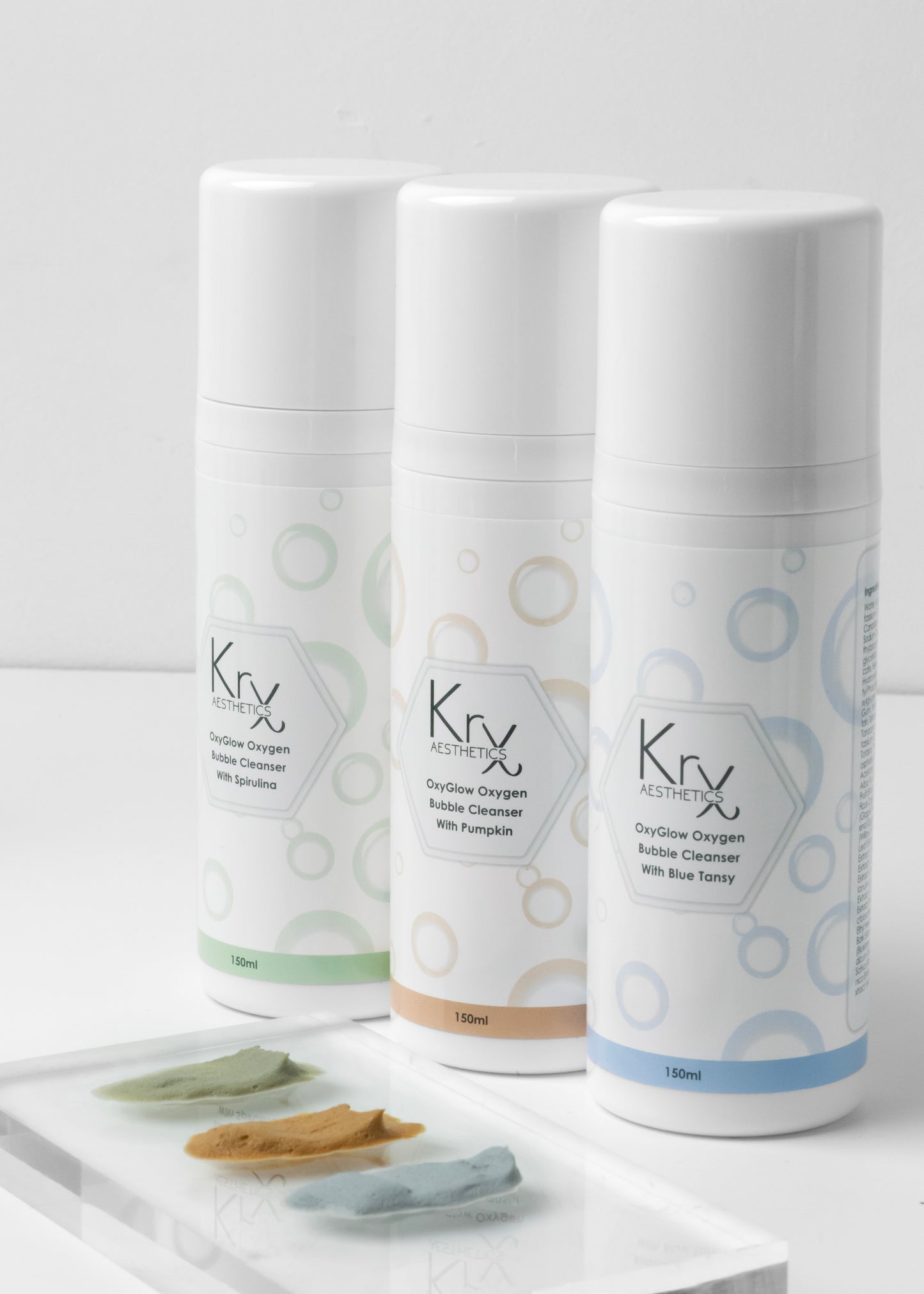 The KrX Aesthetics professional cleanser lineup featuring the OxyGlow Pumpkin Bubble Cleanser, Green Tea, and Blue Lotus formulas for a customized clinical skincare routine.