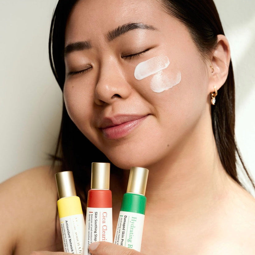 Applying Thesera Mela Touch On Korean Brightening Cream to cheeks to neutralize blue light damage and restore a radiant, even skin tone.