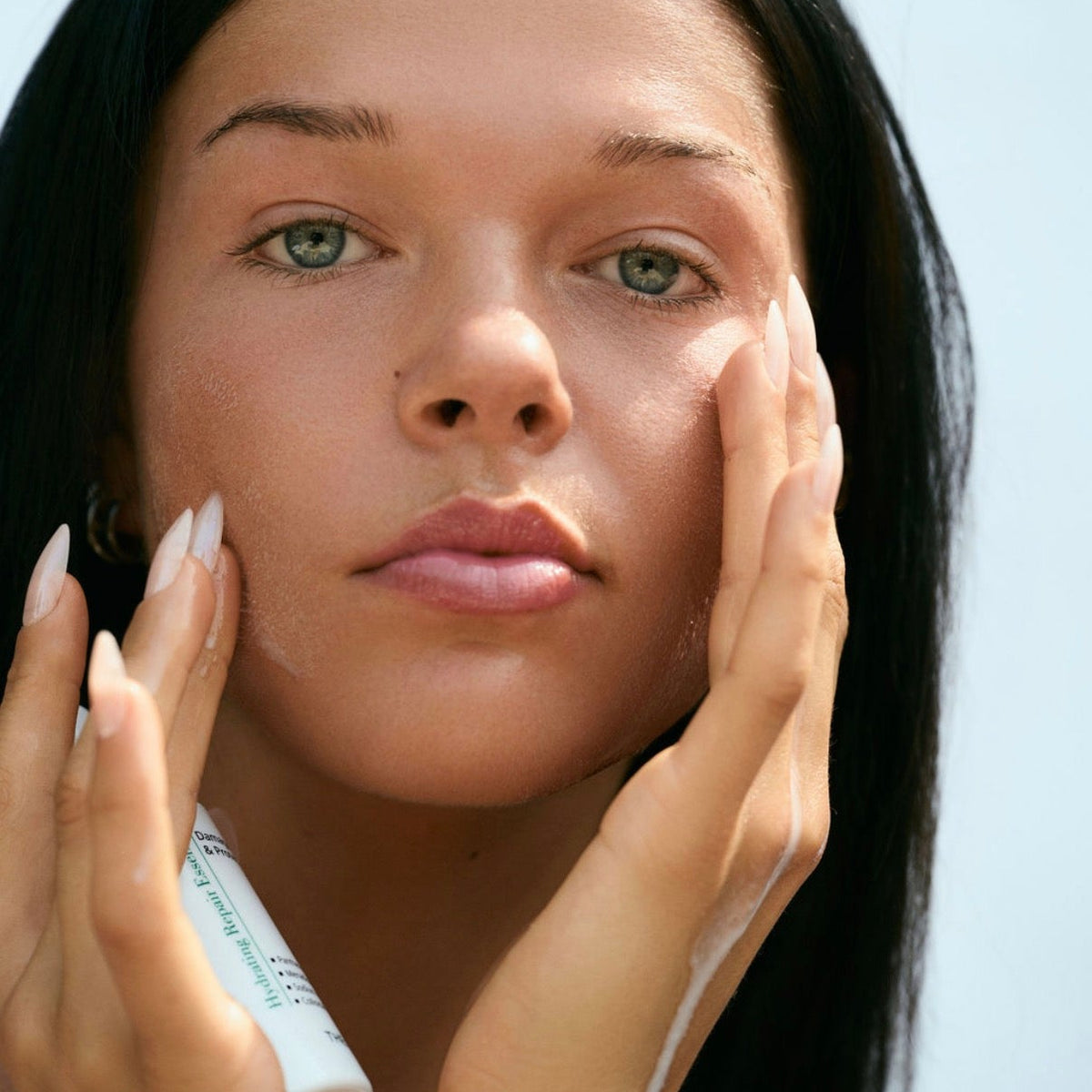 Applying gentle Thesera Hydrating Repair Essence to calm post-laser redness, stinging, and skin barrier reactivity.